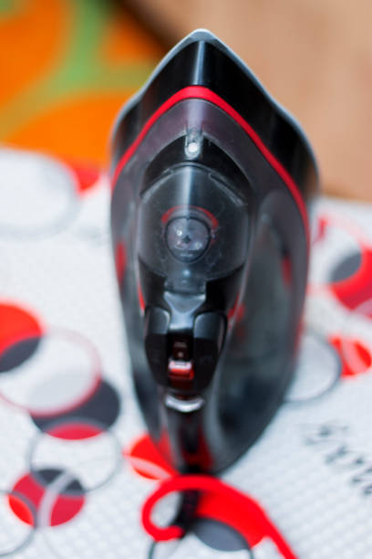 istock Iron stand vertically on the ironing board closeup 1334585242