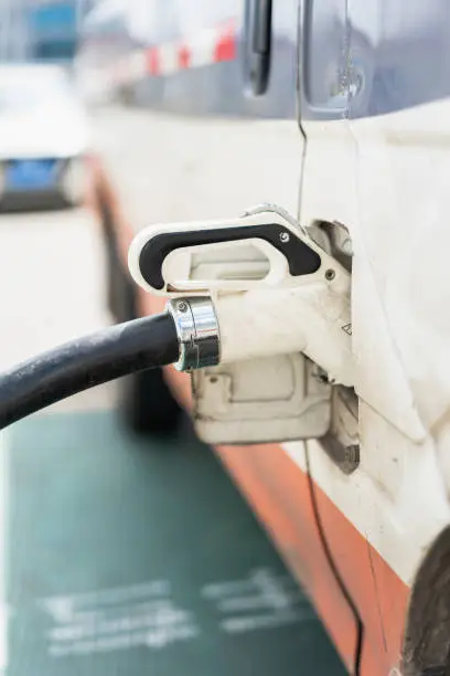 For electric vehicles at charging stations, the power cord is plugged into the charging port. Modern green energy, environmentally friendly transportation concept