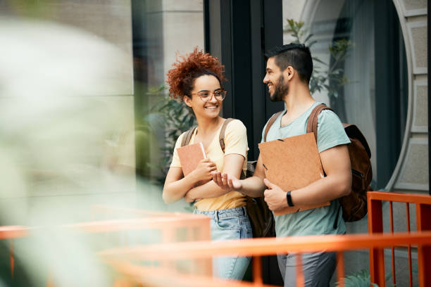 istock Happy college students communicating while walking outdoors. 1334587793