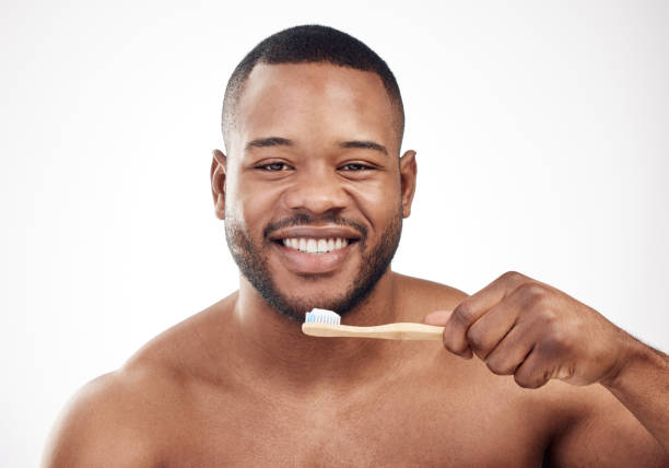istock Studio portrait of a handsome young man brushing his teeth against a white background 1334587997