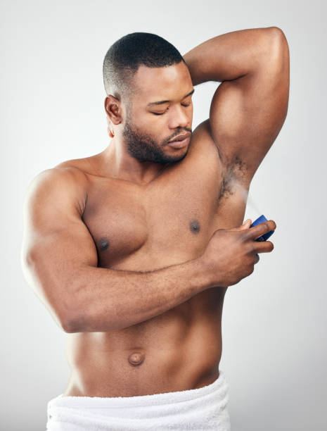istock Studio shot of a handsome young man spraying deodorant on his armpit against a white background 1334588080