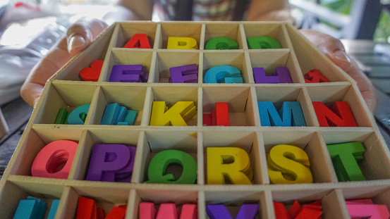 Hands holding - Colorful alphabet letters on wooden box.Provided for creative artworks.