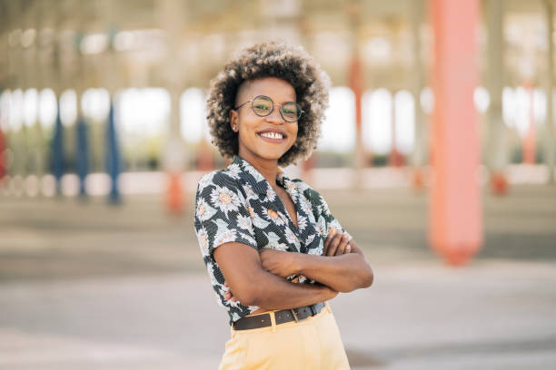 istock pretty afro woman smiling looks at camera with cool pose 1334589268