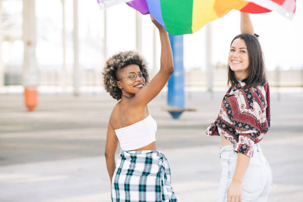 istock two protesting friends walk happily while holding a lgbt flag 1334589274