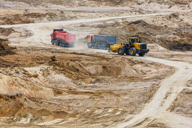 istock A loader and dump trucks are working in a sand quarry 1334590137