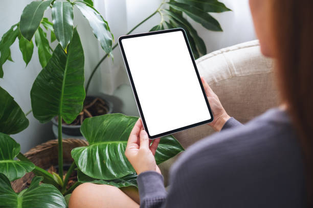 istock a woman holding digital tablet with blank white desktop screen at home 1334590194