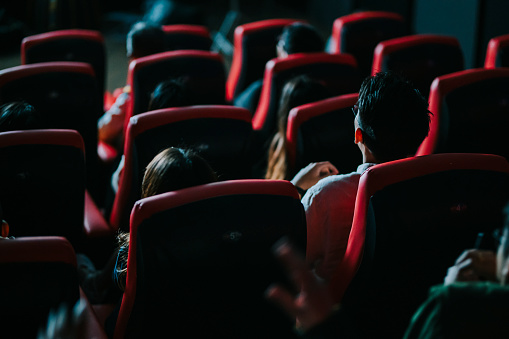 vista trasera grupo chino asiático de público viendo películas en 3D en el cine disfrutando del espectáculo con gafas 3D gritando emoción photo
