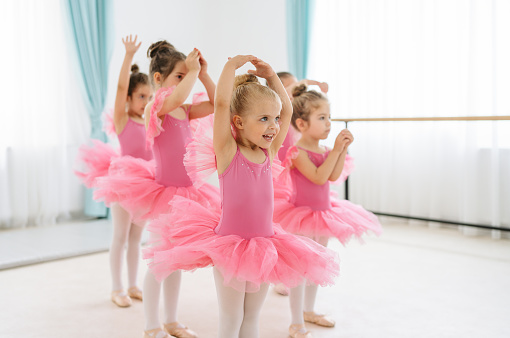 Photo of sweet little ballerinas practicing together in a ballet studio.