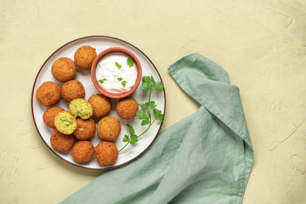 istock Falafel balls with sauce on a beige stucco background. Top view, flat lay, copy space. 1334601933