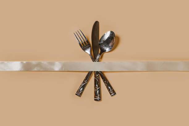 A set of cutlery - fork, spoon and knife. Top view. Pastel background