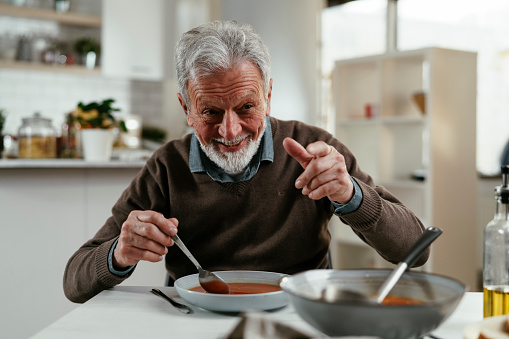 Senior man eating lunch. Old man eating at home.