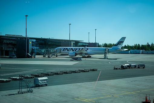 The image shows the view from the window of the Food Court at Recife/Guararapes International Airport - Gilberto Freyre, the main airport in the Northeast Region of Brazil, with a plane on board on the runway ready for boarding on a sunny day.