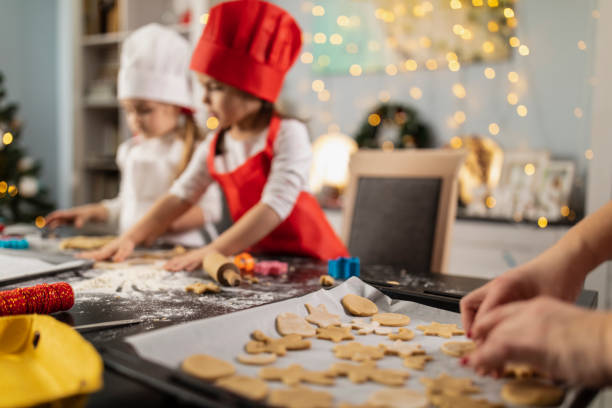 istock Woman arranging gingerbread cookies on a baking sheet 1334609884
