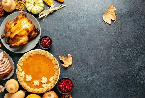 Thanksgiving traditional food for festive charity or family and friends dinner party, top-down view, blank space for a greeting text