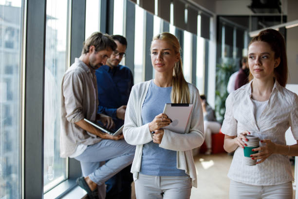 istock Two businesswomen walking through office hall, going on a coffee break 1334610997