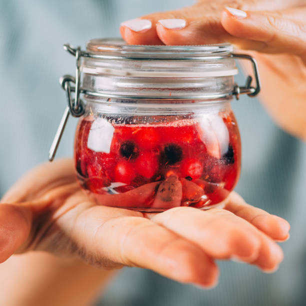istock Woman Holding Jar with Fermented Fruit. 1334611099