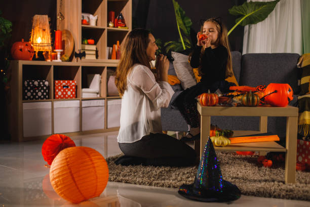 kobieta i jej mała córeczka balony, aby ozdobić salon na halloween - house halloween autumn candid zdjęcia i obrazy z banku zdjęć