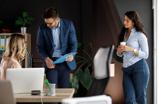 istock Businessman asking his female colleague for help with project documents 1334611751
