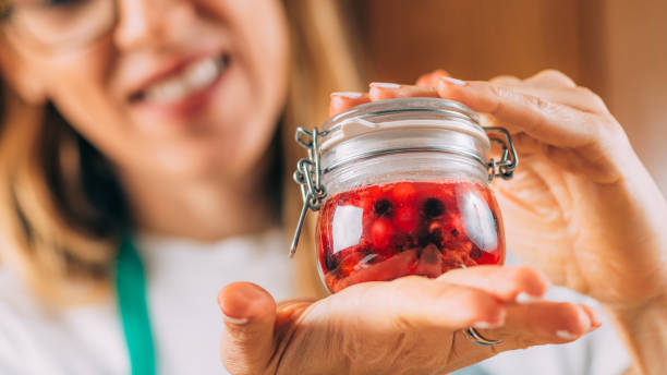 istock Woman Holding Jar with Fermented Fruit. 1334613176