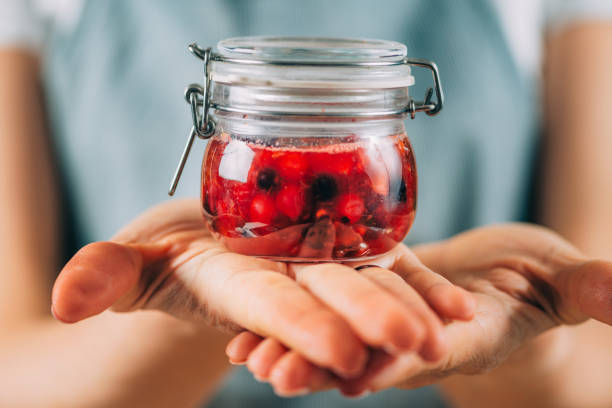 istock Woman Holding Jar with Fermented Fruit. 1334613217