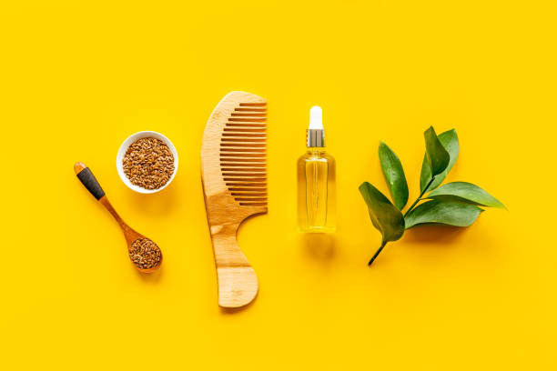 Hair treatment oil with seeds and wooden hair comb. Top view stock photo