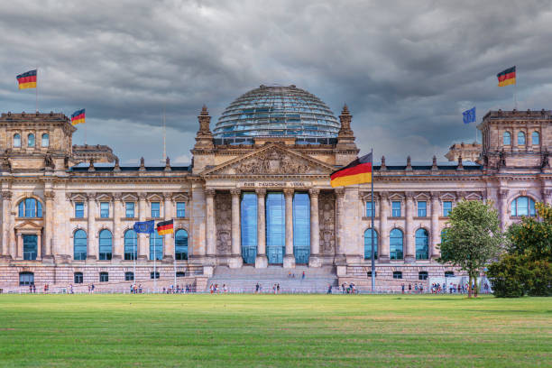 istock Reichstag, german parliament under dark sky with german flags 1334620068