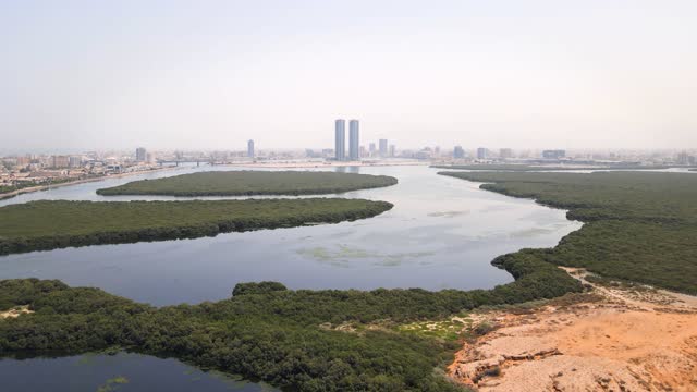 Ras al Khaimah emirate aerial cityscape landmark skyline rising over the mangroves and the creek water surrounded by seaside and coastline in the United Arab Emirates aerial view