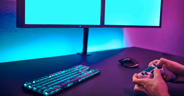 istock Male player using computer keyboard and mouse. Blank monitor to insert your content. 1334622549