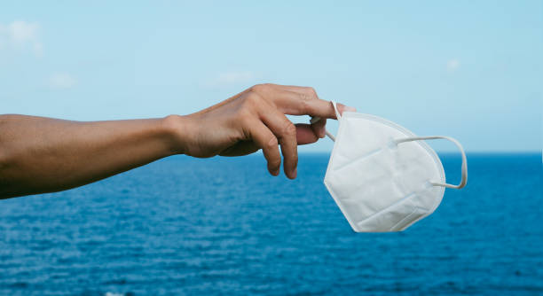 istock has a FFP2 face mask in his hand, web banner 1334623354