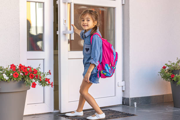 istock A cute little elementary school student opens the doors of the school. 1334624477