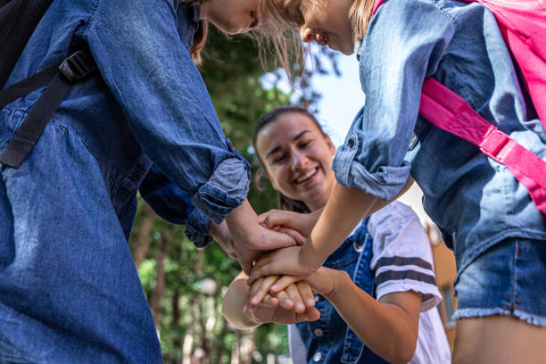 istock Cheerful young mother and little daughters with backpacks before school lessons. 1334624495