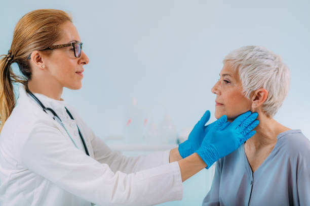 Doctor Examining a Senior Woman with Thyroid Gland Disease Symptoms Endocrinology doctor examining a senior woman with thyroid gland disease symptoms lymphoma photos stock pictures, royalty-free photos & images