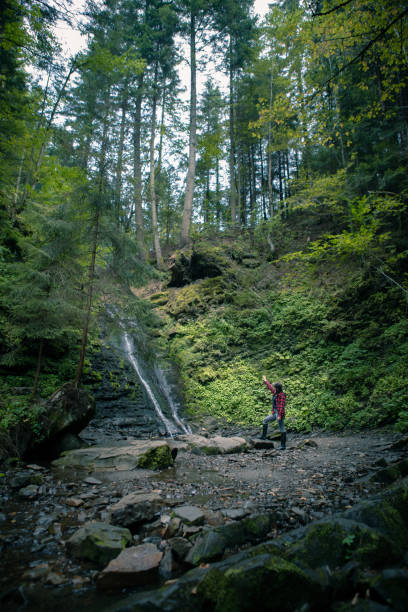 istock young hiking woman looking at waterfall 1334626820