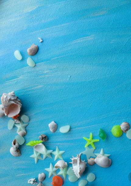 istock Seashells summer background. Many different seashells, starfish on a background of turquoise paint strokes. Place for text with border at the bottom edge 1334627892