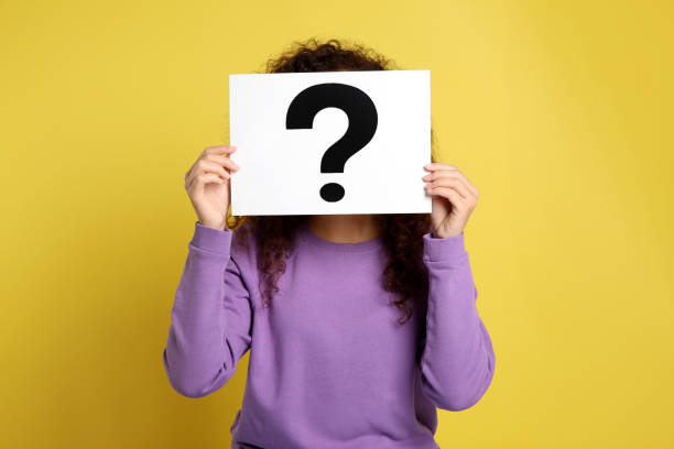 istock Woman with question mark sign on yellow background 1334628259