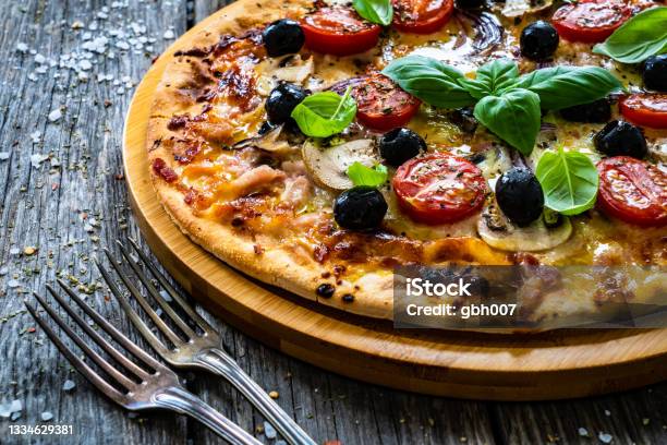 Tasty Pepperoni Pizza With Salami White Mushrooms Mozzarella And Vegetables On Wooden Background Stock Photo - Download Image Now
