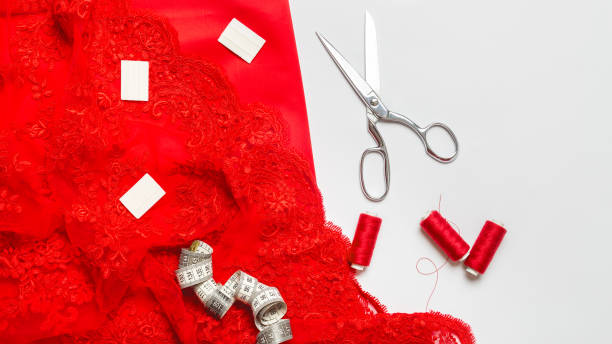 istock Women hobby. Sewing accessories. Set for tailor shop with thread, scissors, red fabric on white background top view copy space 1334629889