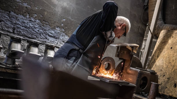 istock Man processing product on old grinding machine. Producing orange hot glow sparks. 1334631281