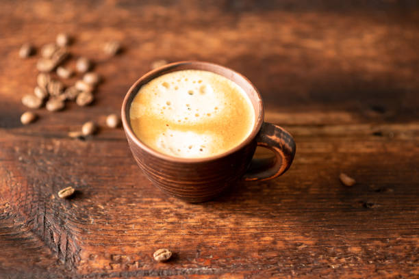 istock Cup with coffee and coffee beans on a wooden background. 1334632530