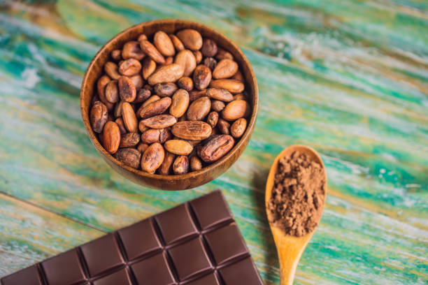 cioccolata e fave di cacao su sfondo legno a colori - healthy eating eating food and drink beer nuts foto e immagini stock