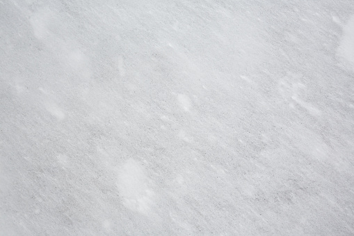 Texture of gray stone covered with a thin layer of white snow
