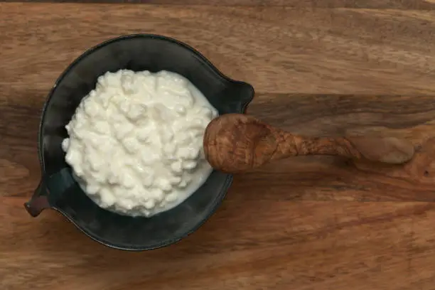 Photo of simple still life with cottage cheese in a ceramic bowl