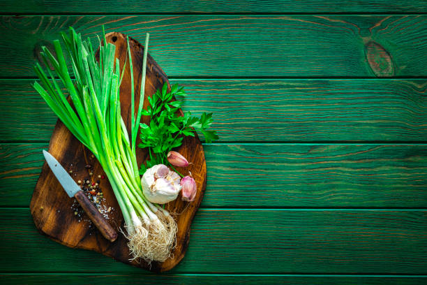 istock Cutting board with scallion, parsley, garlic and salt. Copy space 1334636817