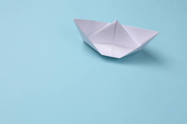 istock Paper origami boat on a blue background 1334636936