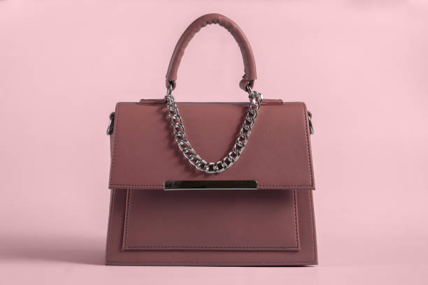 istock Brown handbag isolated in pink background 1334637484