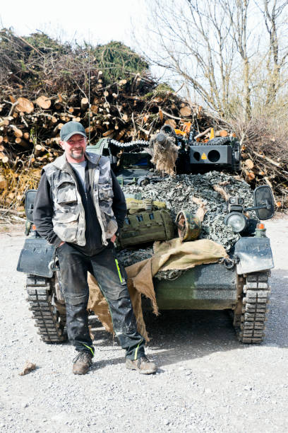 Military Veteran in front of an infantry fighting vehicle Veteran of the German Federal Armed Forces in front of an infantry fighting vehicle called the Wiesel. The Wiesel is a German light tracked vehicle platform and exists in different versions for reconnaissance, leadership, effectiveness and support purposes. In connection with the annual flight exercise of the parachutists and pioneers of the Bundeswehr, who held their exercises at Lake Kochelsee in Upper Bavaria, veterans exhibited vehicles. armored tank photos stock pictures, royalty-free photos & images