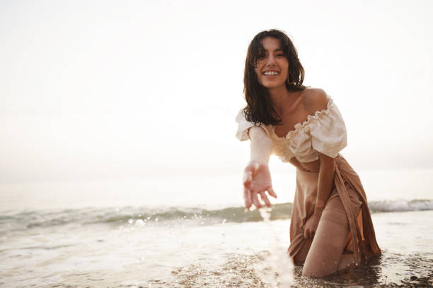 istock Young relaxed woman sitting all alone on empty beach 1334640176