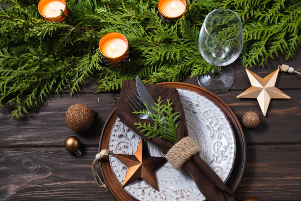 istock Festive table setting with Christmas decorations, fir branches and candles on wooden background. 1334641246