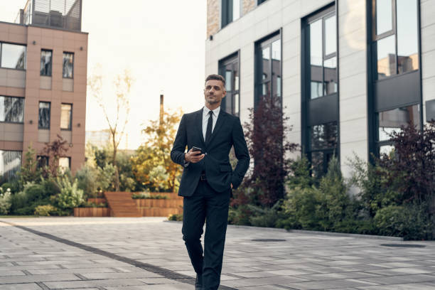 istock Confident mature businessman holding mobile phone 1334643706