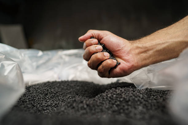 istock Close up of male hand holding plastic polymer granules 1334643714